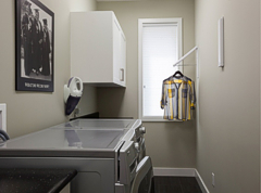 Handy wall attachments flip down for extra hanging space in the laundry room. Photograph by: Debra Brash